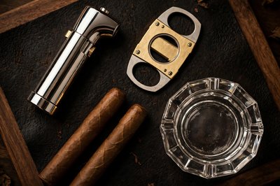 Lighter, cigar cutter and crystal ashtray on dark leather