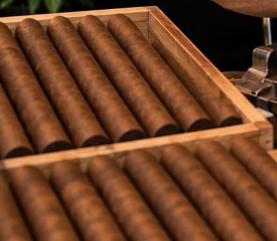 Stack of premium hand-rolled cigars with cream and gold bands